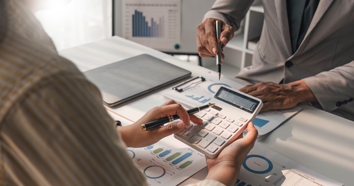 Two people calculating the tax implications related to Panamanian Mergers and Acquisitions 
