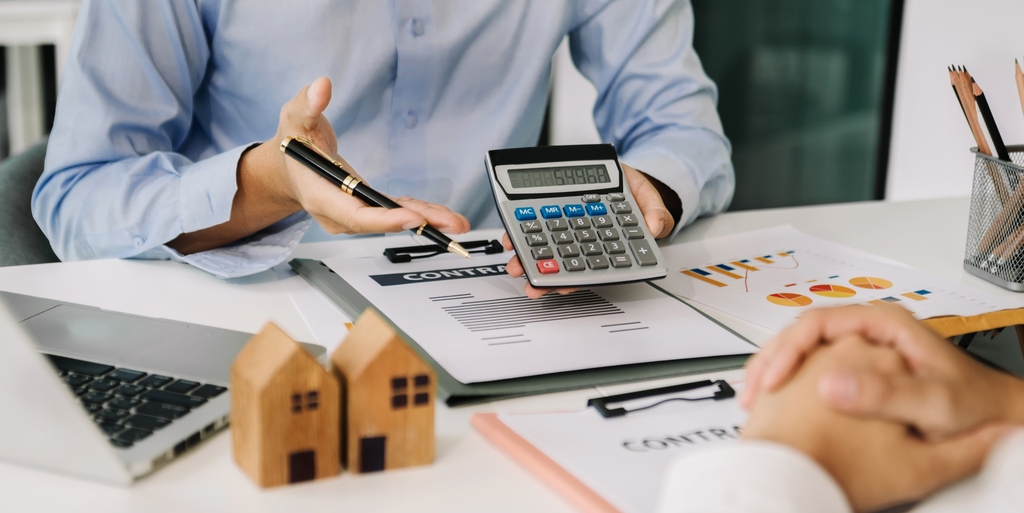 Personas revisando documentos financieros relacionados con la debida diligencia inmobiliaria.